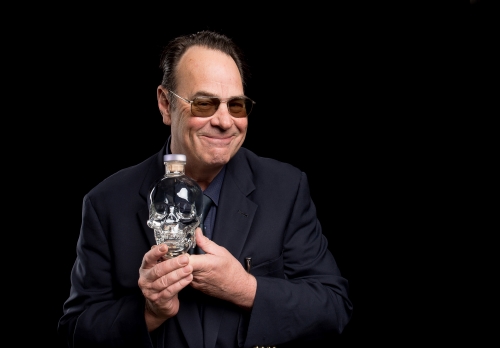 Dan Akyroyd Holding a bottle of Crystal Skull Head vodka