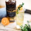 Morvenna Spiced Rum bottle blurred in the background with a tall cocktail