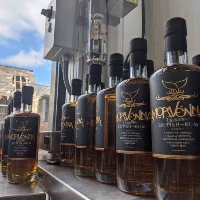 Morvenna Spiced Rum bottles on a production line with the sky in the background.