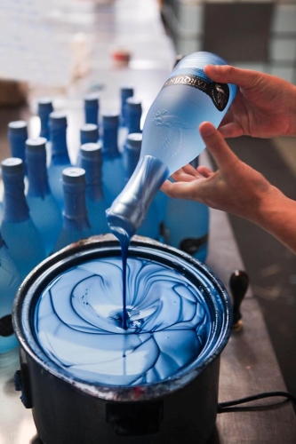 Southwestern Distillery Tarquin's Dry Gin bottle being dipped in blue wax